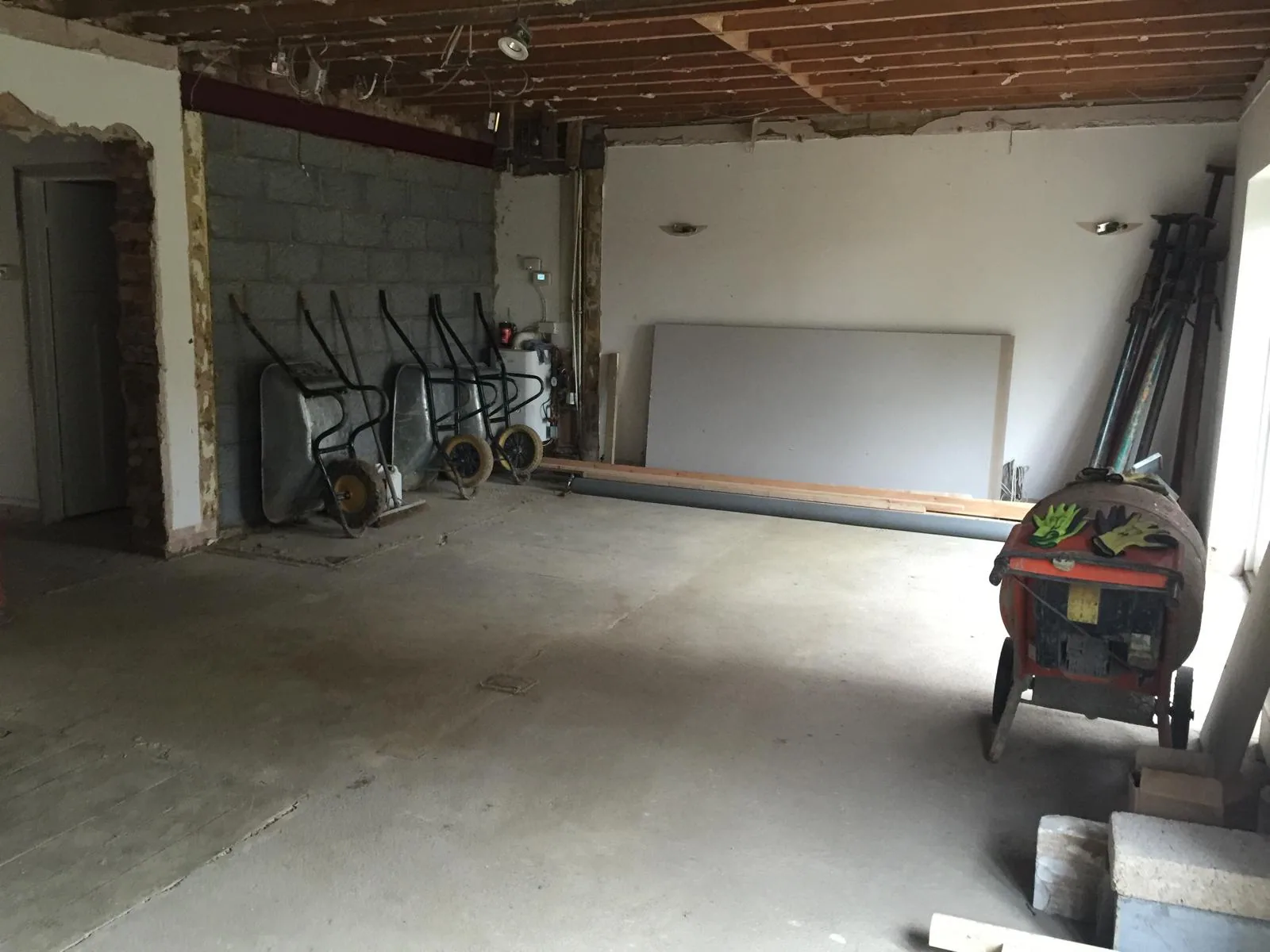 Open-plan kitchen and flooring installation progressing inside the renovation.