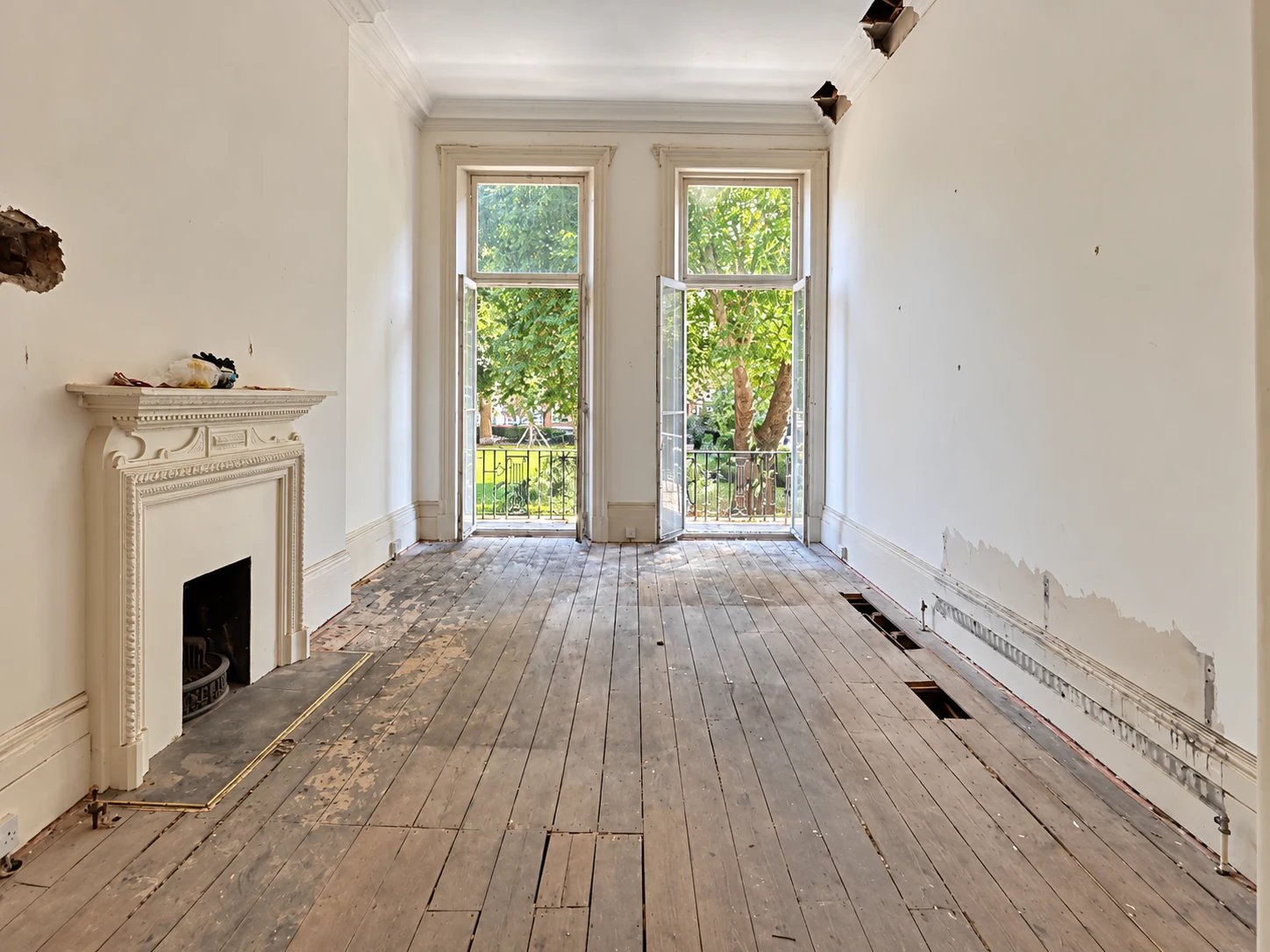 Period residential room stripped back to floor joists and exposed masonry