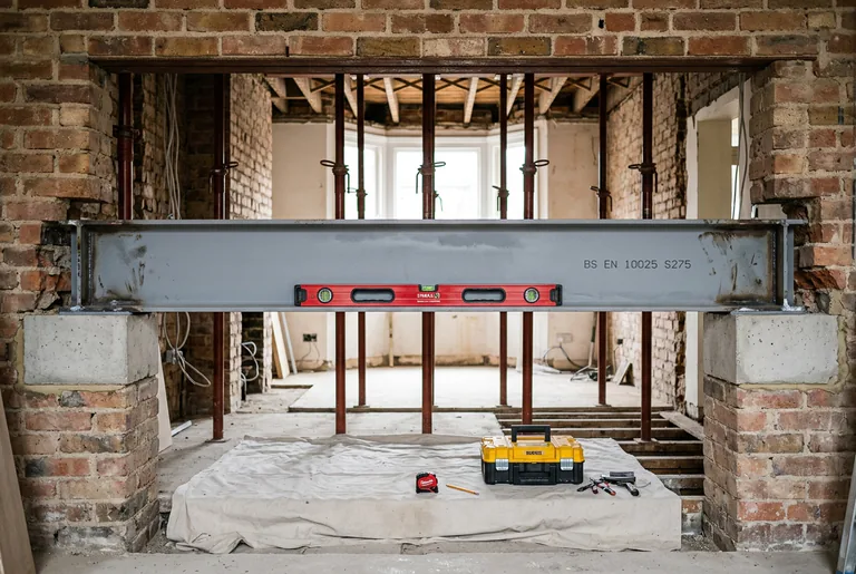 Certified BS EN 10025 structural steel RSJ beam installation on engineered concrete padstones in North London